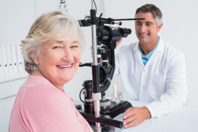 Senior woman smiling while sitting with optician